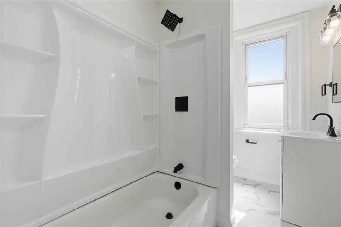 812 Linden Street Bethlehem, PA 18018 - Photo 18 of 39 A pristine bath and shower area features modern fixtures and ample natural light from a well-placed window.