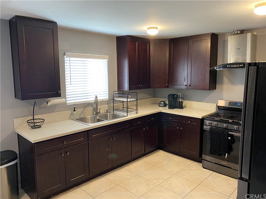 823 East 75th Street Los Angeles, CA 90001 - Photo 3 of 13 a kitchen with a sink stove and refrigerator