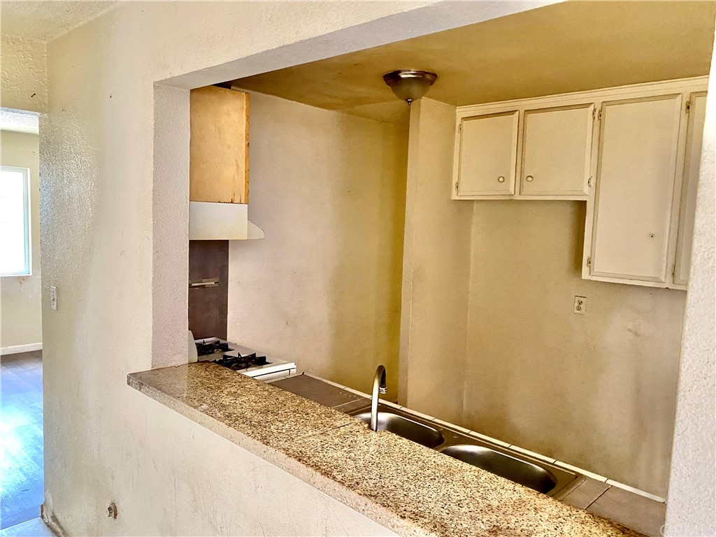 823 East 75th Street Los Angeles, CA 90001 - Photo 7 of 13 a bathroom with a granite countertop sink and a mirror