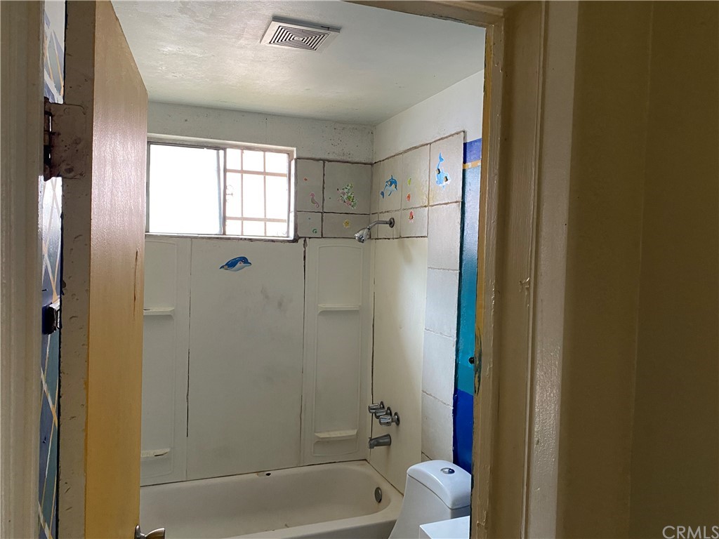 823 East 75th Street Los Angeles, CA 90001 - Photo 9 of 13 a bathroom with a bathtub and shower