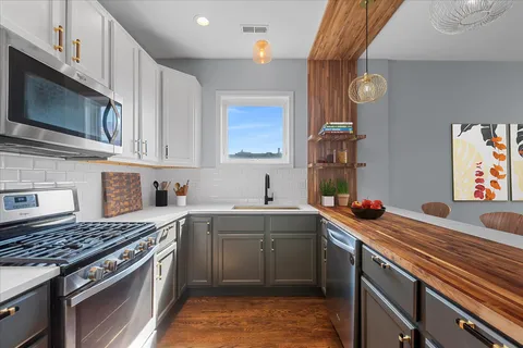 a kitchen with stainless steel appliances a sink a stove and cabinets