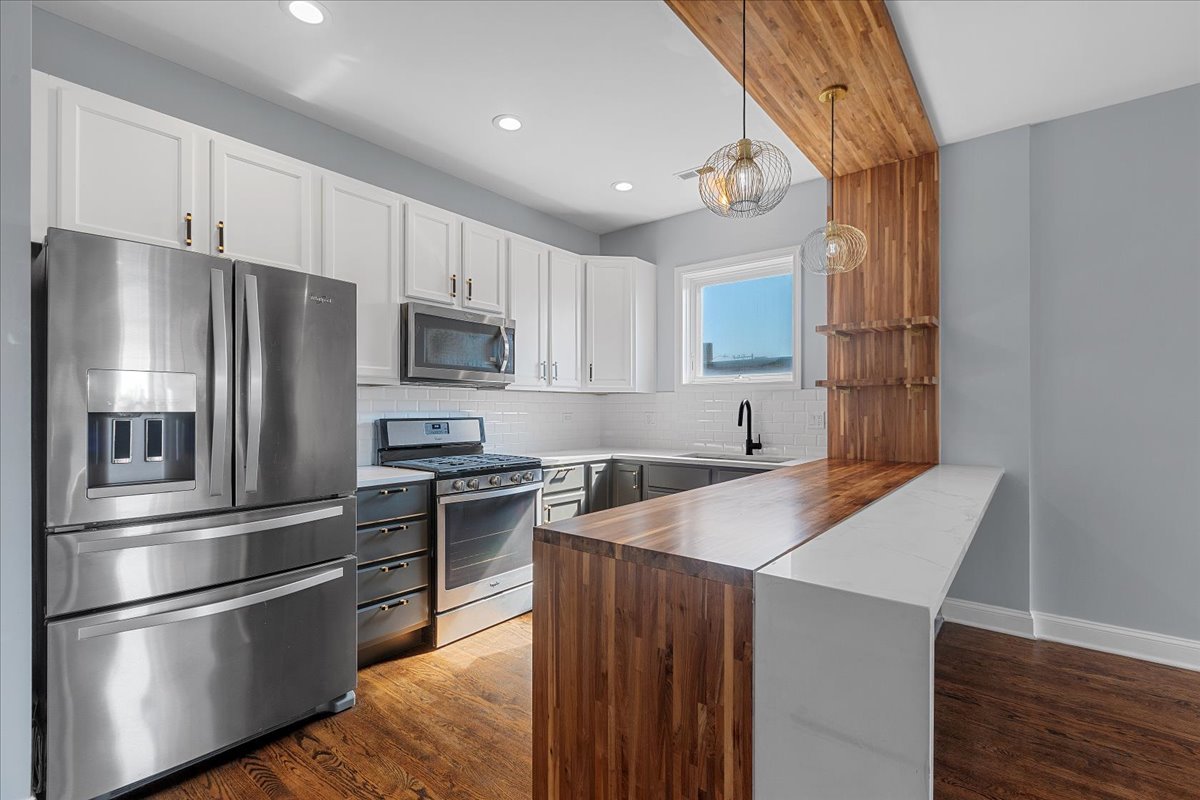 1610 West Grand Avenue, Unit 2C Chicago, IL 60622 - Photo 3 of 13 a kitchen with stainless steel appliances granite countertop a refrigerator a stove top oven a sink and dishwasher