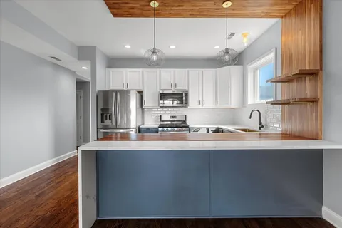 a kitchen with kitchen island sink stove and cabinets