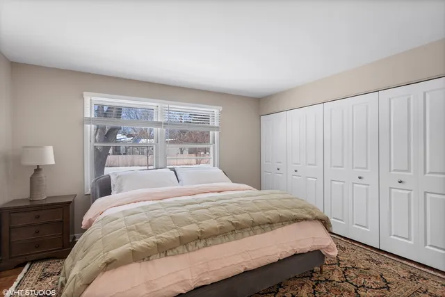 a large bed sitting in a bedroom next to a window