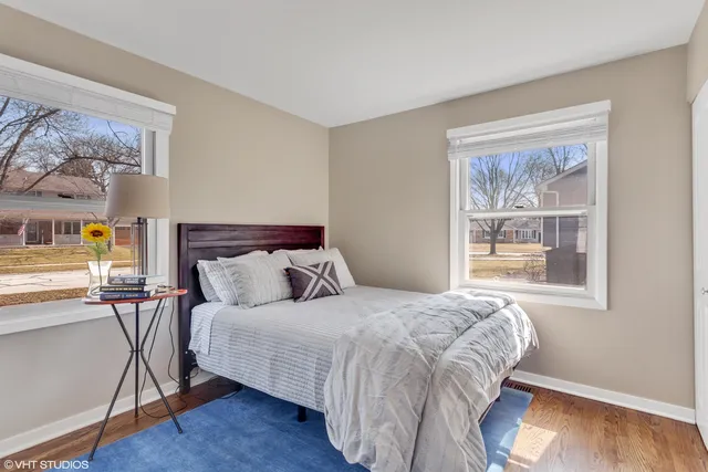 a bedroom with a large bed a painting and a window