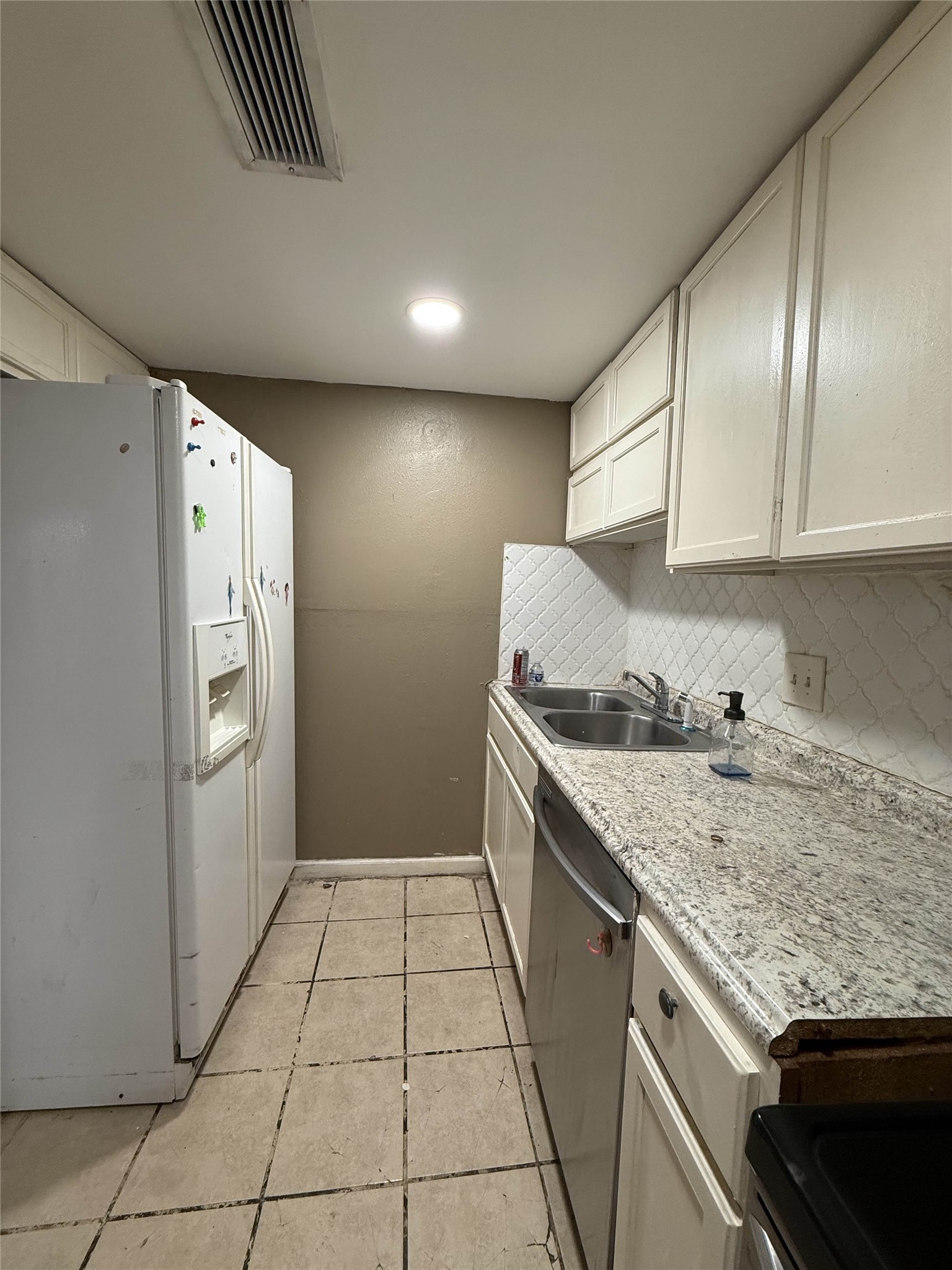 7047 Bissonnet Street, Unit 70 Houston, TX 77074 - Photo 21 of 23 a kitchen with a sink a refrigerator and cabinets