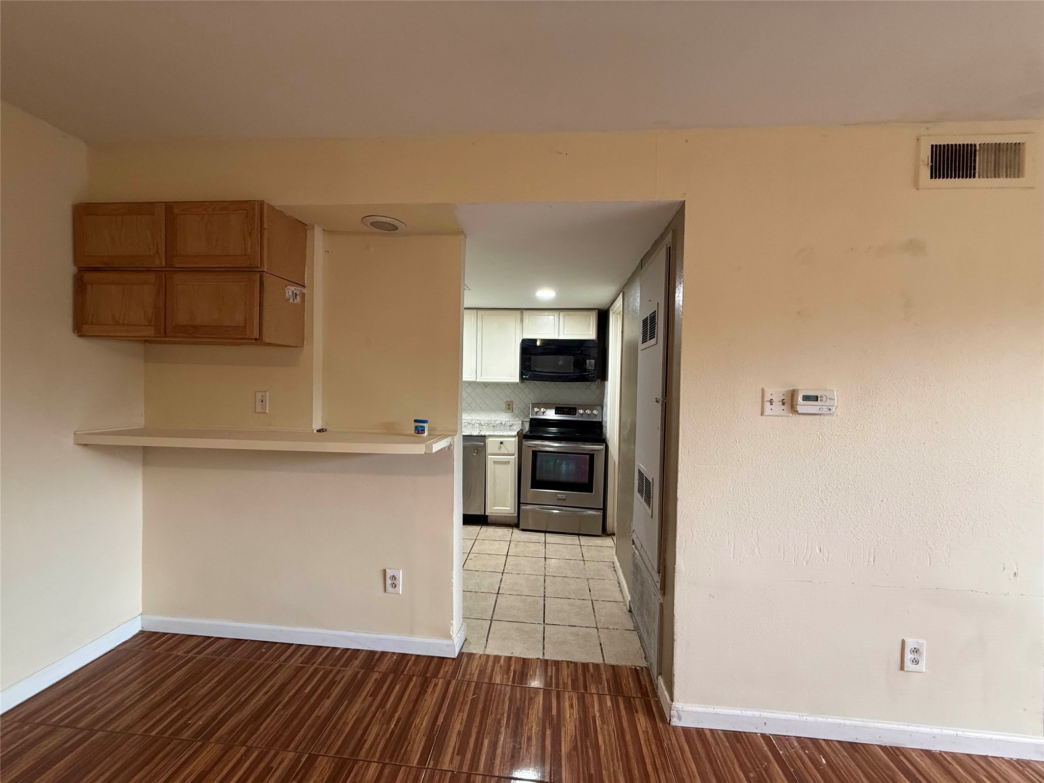7047 Bissonnet Street, Unit 70 Houston, TX 77074 - Photo 7 of 23 a kitchen with wooden floor and a refrigerator