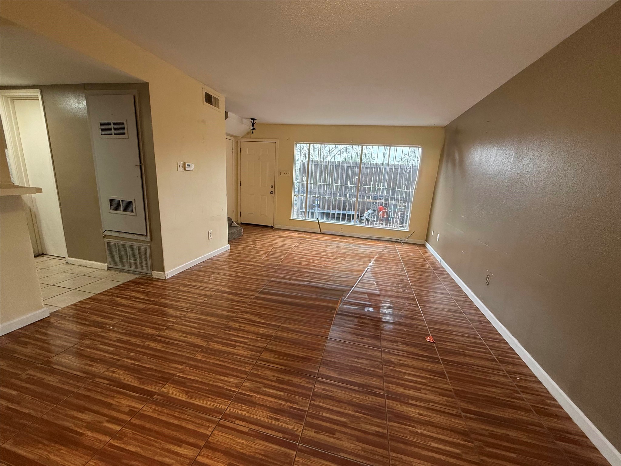 7047 Bissonnet Street, Unit 70 Houston, TX 77074 - Photo 9 of 23 a view of an empty room with wooden floor and a window