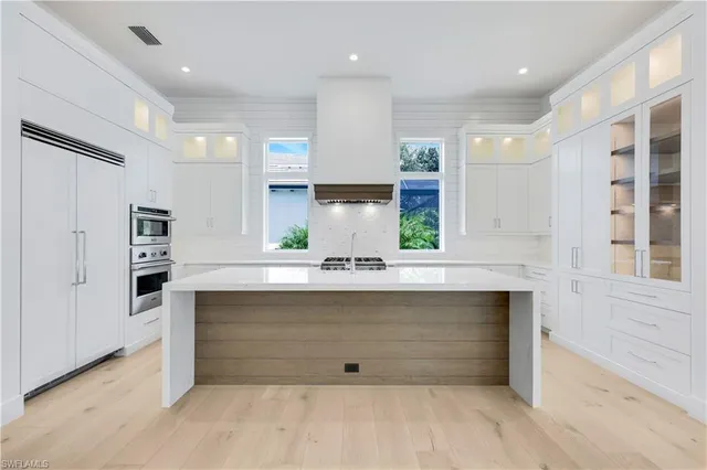 a large white kitchen with a large window