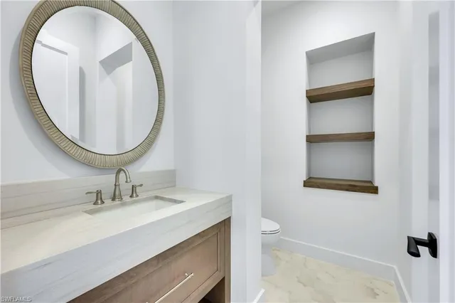 a bathroom with a granite countertop sink a toilet and shower
