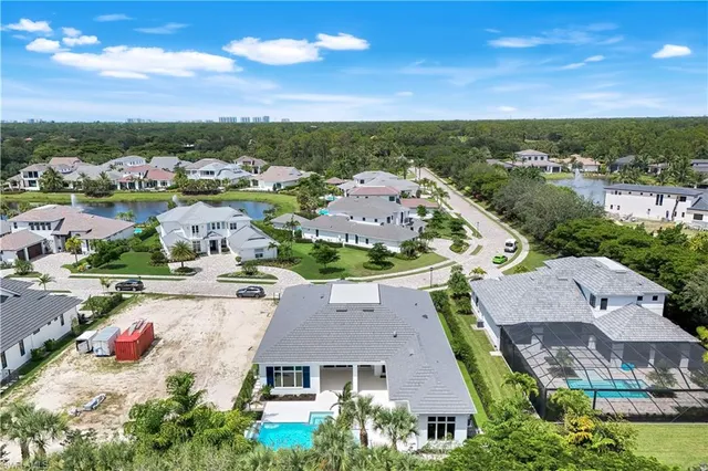 a front view of a house with garden and trees