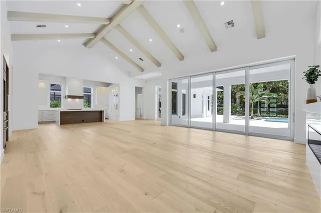 a view of empty room with wooden floor and window