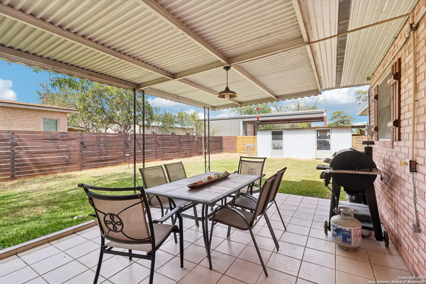 100 North Carroll Street Poth, TX 78147 - Photo 46 of 58 a view of patio with table and chairs and couches with wooden floor and fence