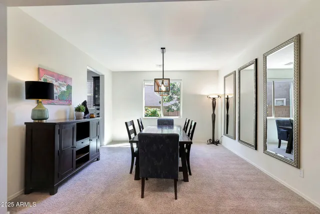 a kitchen with stainless steel appliances kitchen island granite countertop a table chairs sink and cabinets