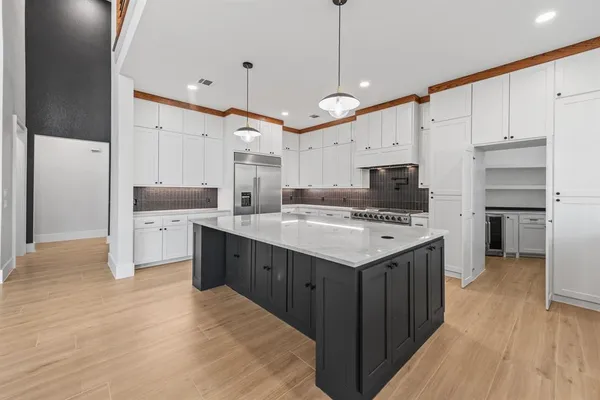 a kitchen that has a lot of cabinets and wooden floor