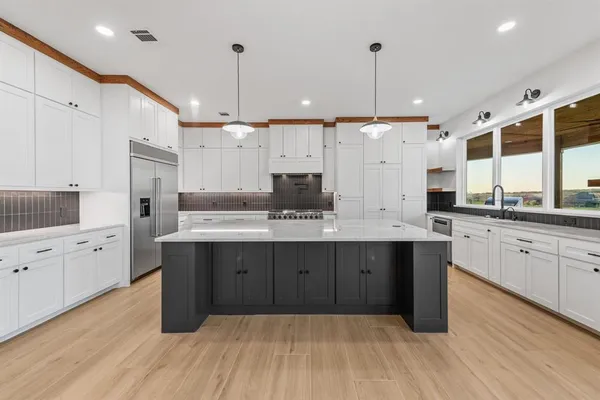 a large kitchen with cabinets and wooden floor