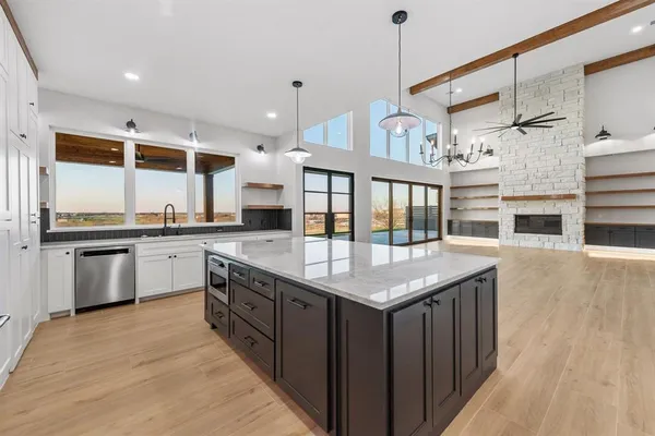 a kitchen with stainless steel appliances granite countertop a kitchen island a stove and a sink