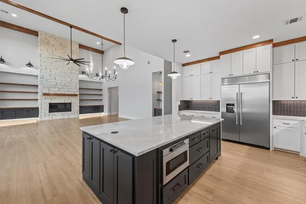 a kitchen with a stove a refrigerator a oven and a kitchen island