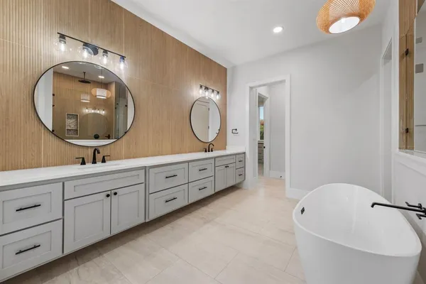 a spacious bathroom with a granite countertop tub and a double vanity sink