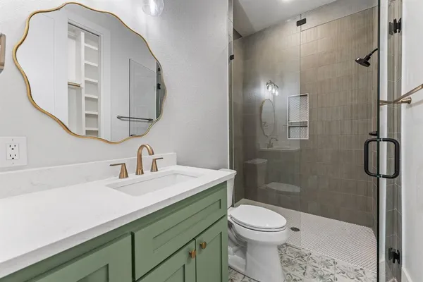 a bathroom with a sink a toilet and shower