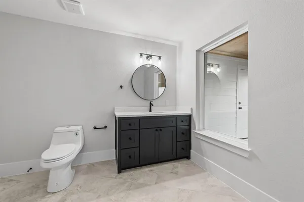 a bathroom with a toilet a sink and mirror