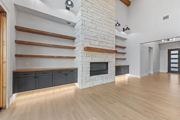 a view of an empty room with a fireplace and a window