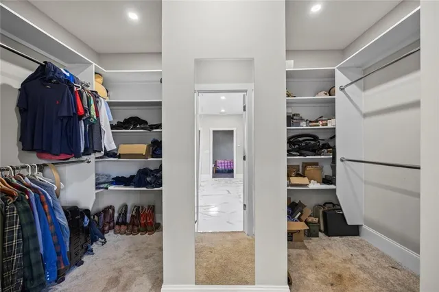 a view of walk in closet with clothes and shoes