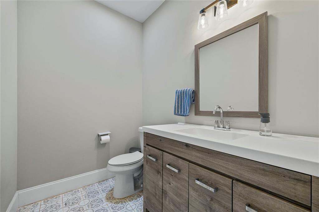 7588 Highway 98 Commerce, GA 30530 - Photo 30 of 50 a bathroom with a granite countertop toilet a sink and a mirror