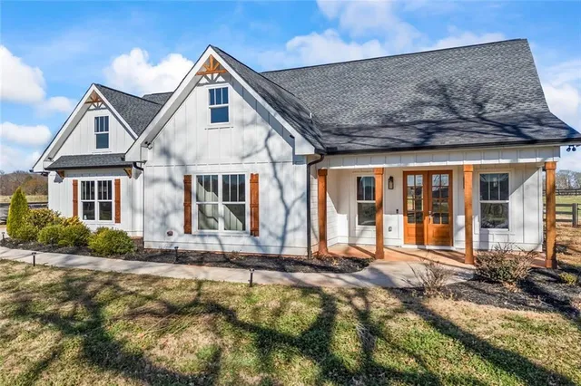 a kitchen with stainless steel appliances granite countertop a table chairs sink and cabinets