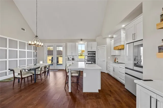a kitchen with stainless steel appliances kitchen island a refrigerator sink and cabinets