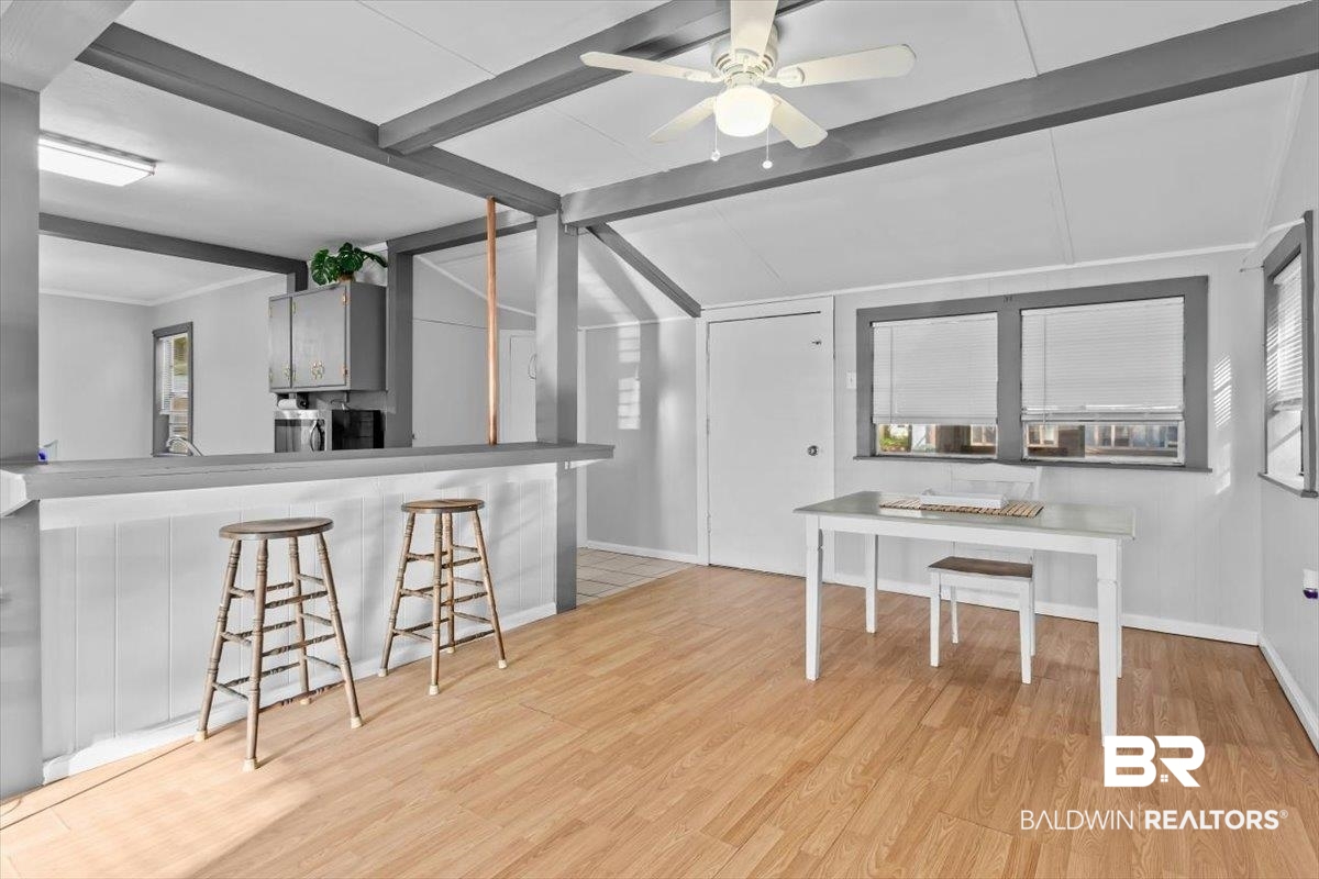 4918 Quimby Drive Mobile, AL 36619 - Photo 6 of 38 Kitchen with beamed ceiling, wood finished floors, baseboards, ceiling fan, and a kitchen breakfast bar