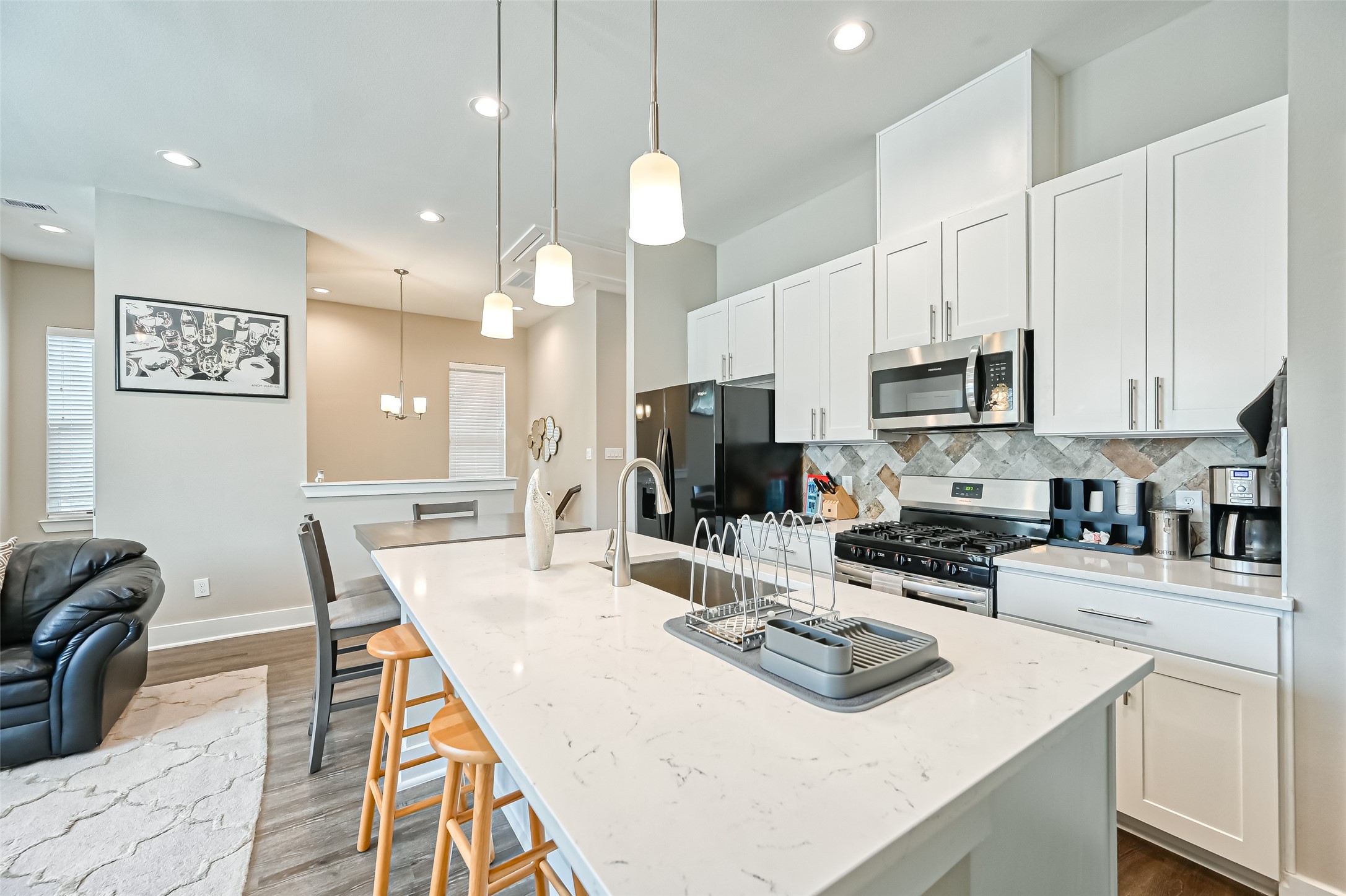 882 Fortune Street Houston, TX 77088 - Photo 12 of 18 a kitchen with stainless steel appliances kitchen island granite countertop a sink a stove a oven a dining table with chairs and white cabinets