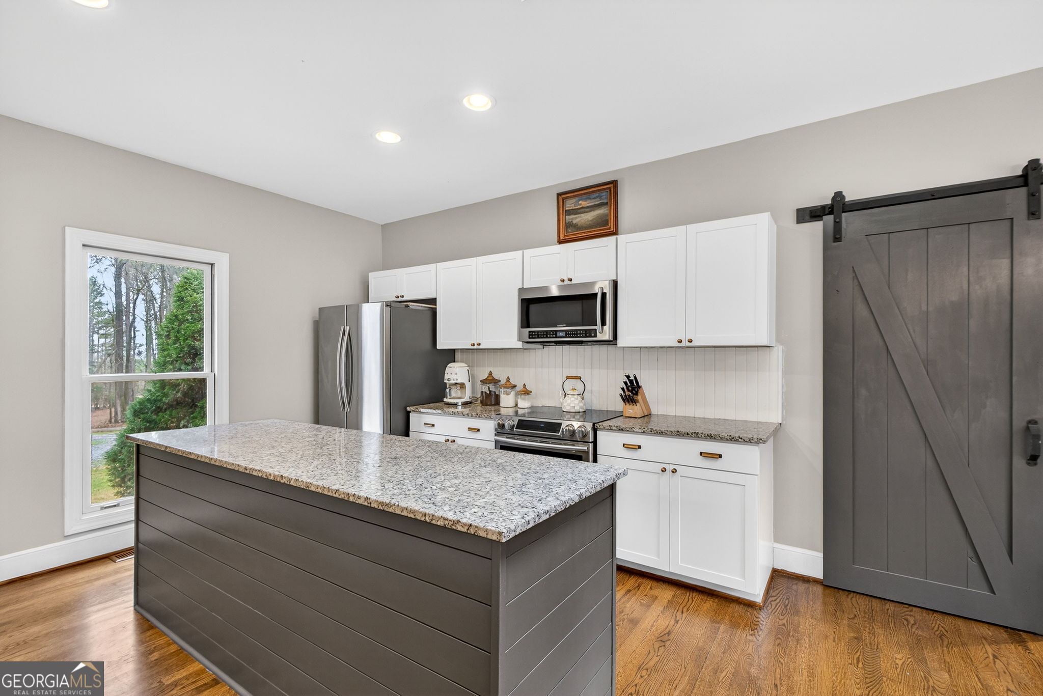 7581 Old Zebulon Road Molena, GA 30258 - Photo 19 of 79 a kitchen with kitchen island granite countertop a sink cabinets and wooden floor