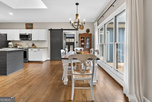 a view of a dining room with furniture a chandelier and wooden floor