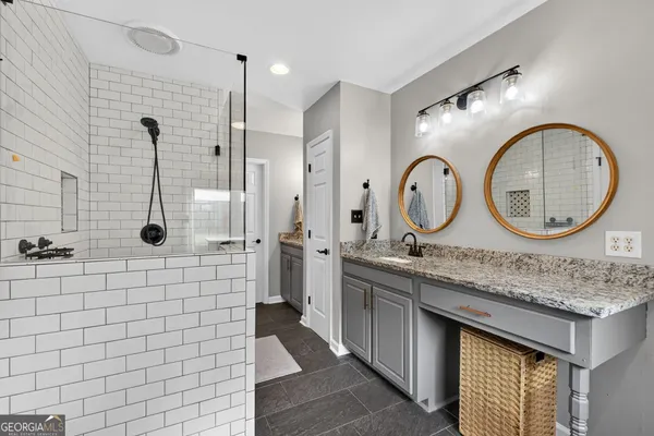 a en suite bathroom with a granite countertop sink and a mirror
