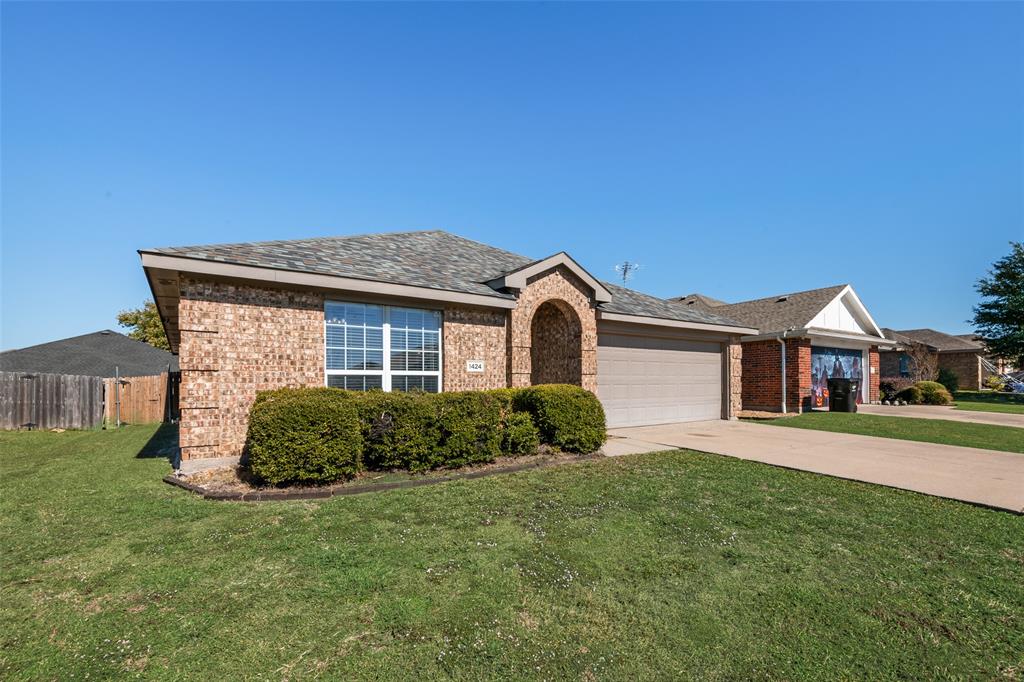 1424 Jacksons Run Greenville, TX 75402 - Photo 1 of 23 a front view of a house with a garden