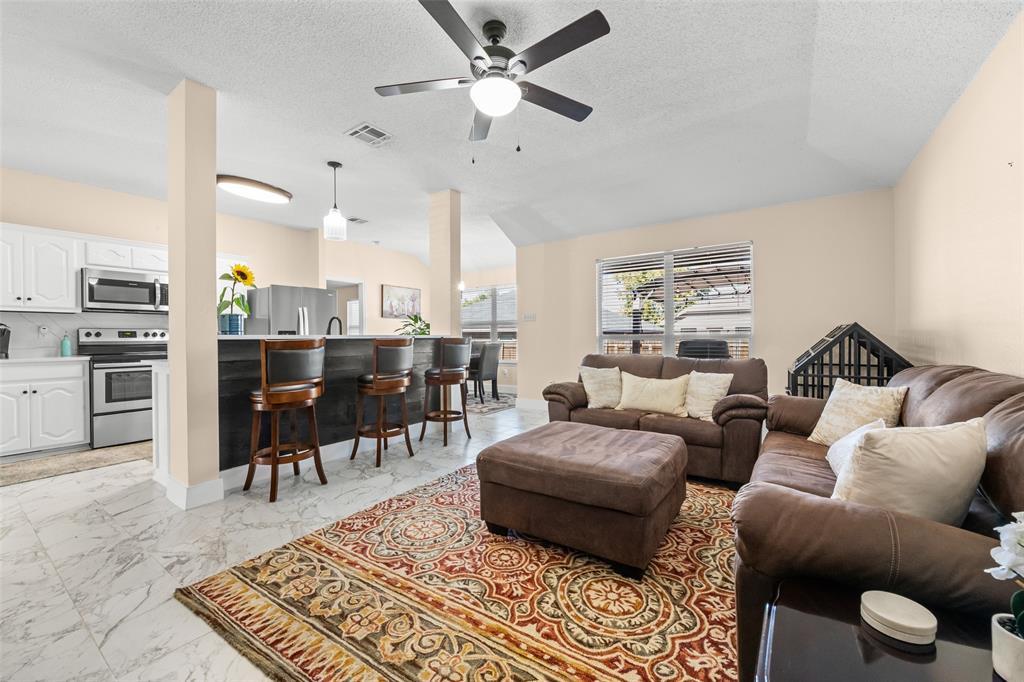 1424 Jacksons Run Greenville, TX 75402 - Photo 5 of 23 a living room with furniture a rug and a chandelier