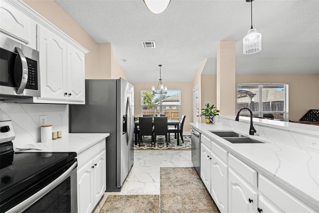 1424 Jacksons Run Greenville, TX 75402 - Photo 8 of 23 a kitchen with granite countertop a sink stove and refrigerator