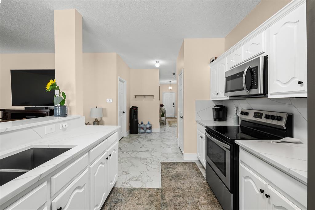 1424 Jacksons Run Greenville, TX 75402 - Photo 9 of 23 a kitchen with a sink stove and microwave