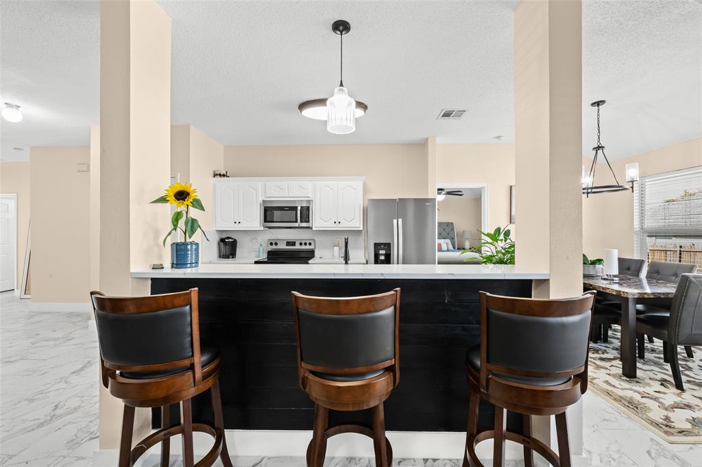 1424 Jacksons Run Greenville, TX 75402 - Photo 10 of 23 a kitchen with stainless steel appliances a dining table chairs and granite counter tops