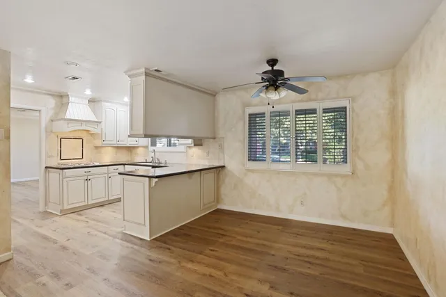 a kitchen with stainless steel appliances granite countertop a sink cabinets and wooden floor