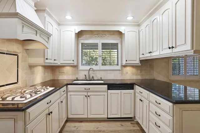 a kitchen with granite countertop white cabinets and white appliances