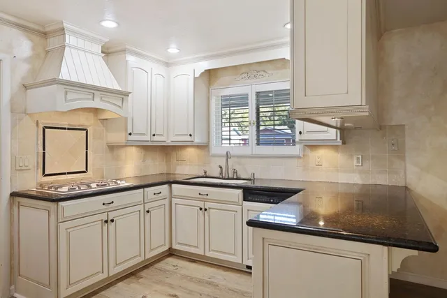 a kitchen with granite countertop white cabinets and white appliances