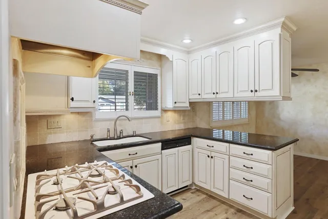 a kitchen with white cabinets and appliances