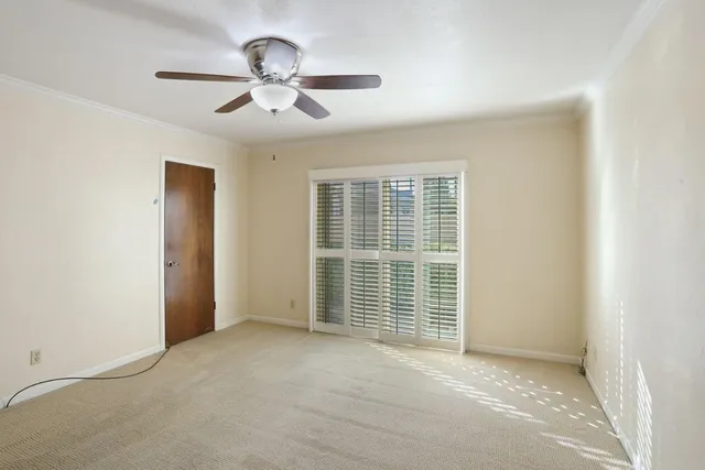 an empty room with chandelier fan