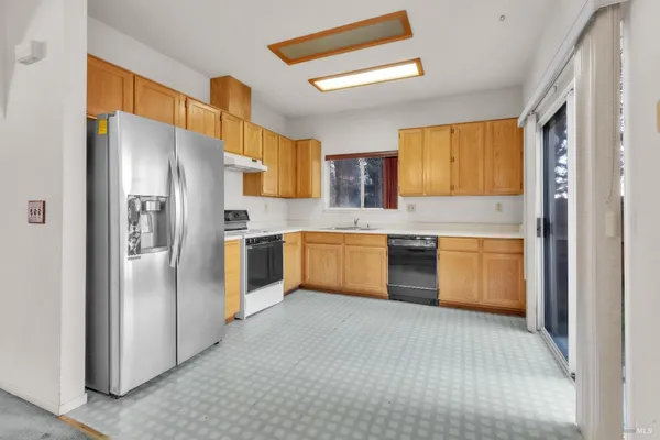 a kitchen with stainless steel appliances a refrigerator sink and cabinets