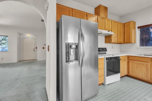 a kitchen with stainless steel appliances granite countertop a refrigerator and a sink