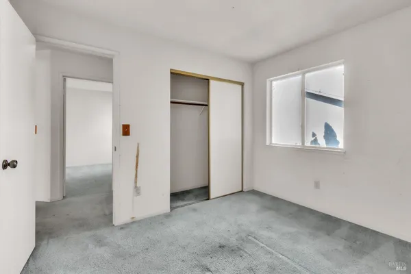 an empty room with windows and closet
