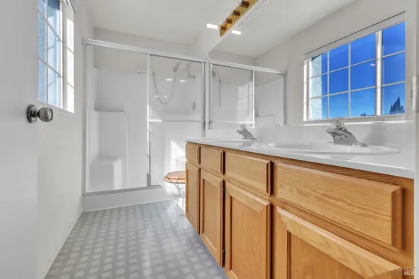a bathroom with a granite countertop sink a mirror and a shower