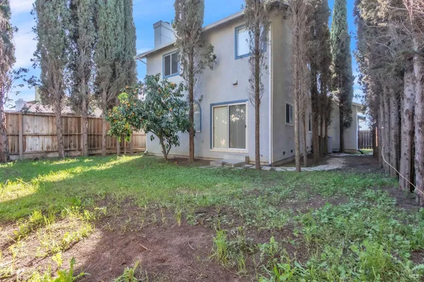a view of a house with backyard and a tree